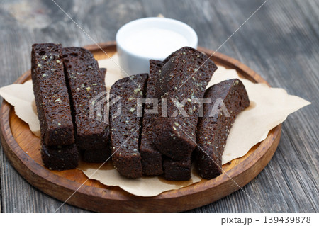 Black garlic bread appetizer with white sauce on a wooden board. Black garlic bread appetizer with white sauce on a wooden board. 139439878