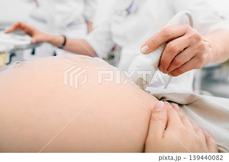 Pregnant woman having sonogram at clinic. Pregnancy ultrasound scan, stomach close-up Pregnant woman having sonogram at clinic. Pregnancy ultrasound scan, stomach close-up 139440082