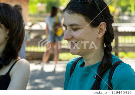 Middle aged woman smiling with eyes closed in summer park Middle aged woman smiling with eyes closed in summer park 139440416