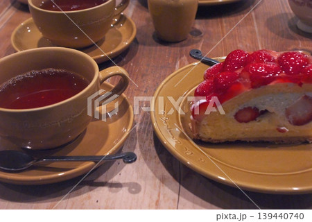木製テーブルの上の紅茶と、イチゴを贅沢に使ったカットタルトケーキ 木製テーブルの上の紅茶と、イチゴを贅沢に使ったカットタルトケーキ 139440740