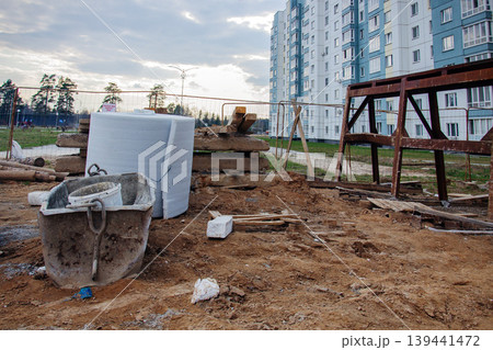 Construction site with building materials and unfinished apartment complex in background 139441472