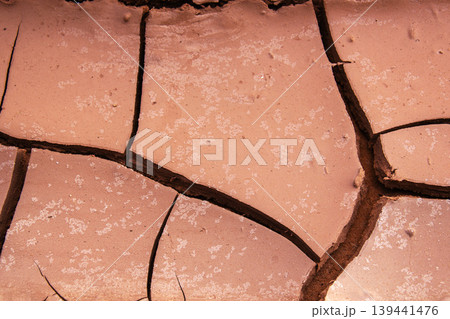 Close-up abstract texture of cracked dry earth with fine salt crystals scattered 139441476