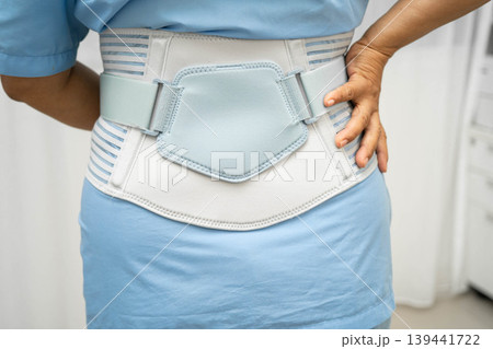 Asian senior pain back wearing elastic support belt with walker. Asian senior pain back wearing elastic support belt with walker. 139441722