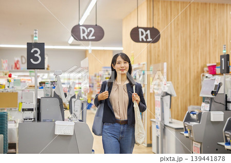 セルフレジで清算を済ませてエコバッグを肩に描ける若い女性 セルフレジで清算を済ませてエコバッグを肩に描ける若い女性 139441878