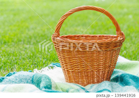 Picnic basket on a green lawn under sunny skies, ready for an outdoor meal Picnic basket on a green lawn under sunny skies, ready for an outdoor meal 139441916