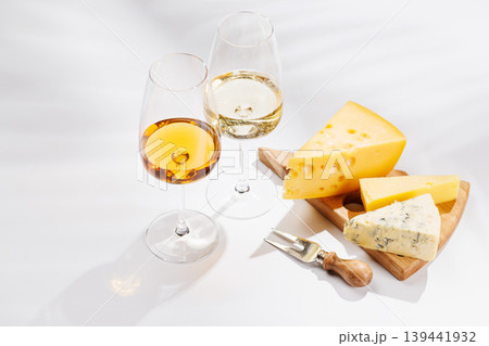 Assorted cheeses and wine glasses on white background 139441932