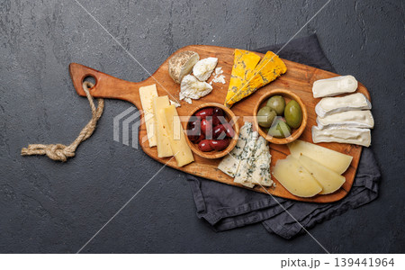 Cheese board with assorted cheeses and olives Cheese board with assorted cheeses and olives 139441964