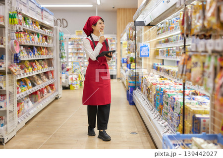 タブレットで商品管理をする若い女性 タブレットで商品管理をする若い女性 139442027