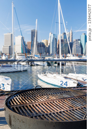 An empty outdoor barbecue grill set against a blurred view of the Manhattan skyline 139442077