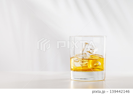 Glass of whiskey with ice cubes on white background Glass of whiskey with ice cubes on white background 139442146