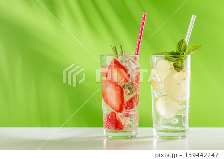 Two fresh non alcoholic drinks with strawberry and lemon on green background Two fresh non alcoholic drinks with strawberry and lemon on green background 139442247