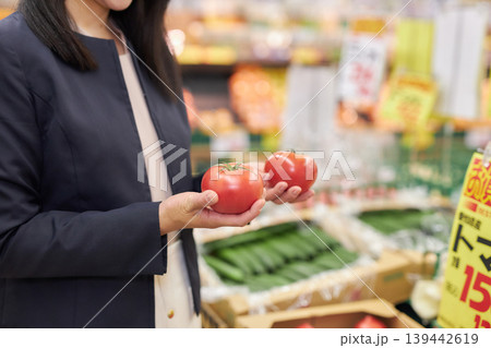仕事帰りにスーパーマーケットで買い物をする若い女性 仕事帰りにスーパーマーケットで買い物をする若い女性 139442619
