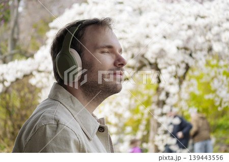 A man listens to a podcast while walking through a Japanese park, filling himself with clarity and promoting personal growth A man listens to a podcast while walking through a Japanese park, filling himself with clarity and promoting personal growth 139443556
