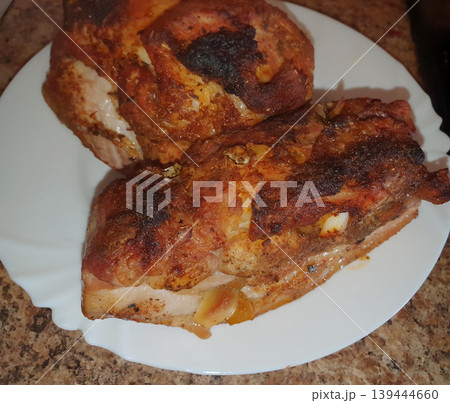Appetizing baked meat with spices and garlic on a white plate. Juicy pork with a ruddy crust, cooked at home Appetizing baked meat with spices and garlic on a white plate. Juicy pork with a ruddy crust, cooked at home 139444660