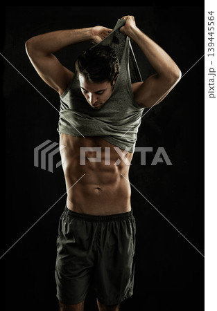 Off, black background or shirt of man with six pack, strong abs or stomach in studio for fitness. Model, cool guy or ripped male person with healthy body, dark shadow or abdomen muscle for wellness 139445564
