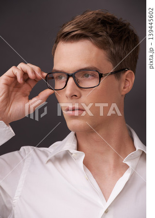 Man, thinking and serious nerd with glasses, fashion or choice in eyewear on dark background of studio. Optometry, check and geek with spectacles, style and person with prescription lenses in frame Man, thinking and serious nerd with glasses, fashion or choice in eyewear on dark background of studio. Optometry, check and geek with spectacles, style and person with prescription lenses in frame 139445602