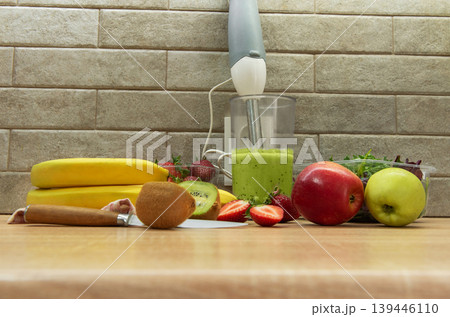Preparing a healthy green smoothie with fresh fruits 139446110