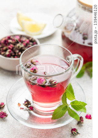 Rose tea in clear cup with mint and dried buds Rose tea in clear cup with mint and dried buds 139446120