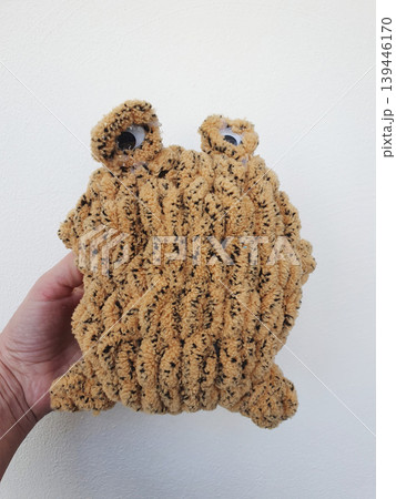 A soft, handmade knitted toy in the shape of a funny brown monster A soft, handmade knitted toy in the shape of a funny brown monster 139446170