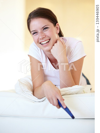 Smile, funny and a woman watching tv on a sofa in the living room of her home for entertainment. Relax, laughing and streaming with a happy young person holding a remote for a television subscription Smile, funny and a woman watching tv on a sofa in the living room of her home for entertainment. Relax, laughing and streaming with a happy young person holding a remote for a television subscription 139446905
