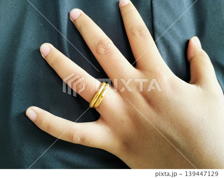 Close up of gold wedding ring. Ring gold wedding on finger hand Close up of gold wedding ring. Ring gold wedding on finger hand 139447129
