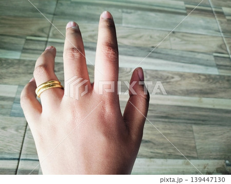 Close up of gold wedding ring. Ring gold wedding on finger hand Close up of gold wedding ring. Ring gold wedding on finger hand 139447130