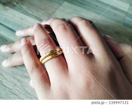 Close up of gold wedding ring. Ring gold wedding on finger hand Close up of gold wedding ring. Ring gold wedding on finger hand 139447131