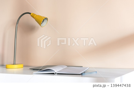 Minimal desk with open notebook and yellow lamp Minimal desk with open notebook and yellow lamp 139447438