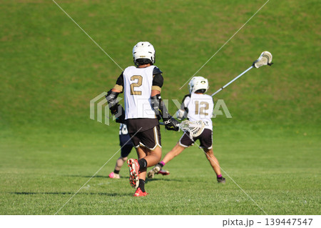 Young boys playing Lacrosse game Young boys playing Lacrosse game 139447547