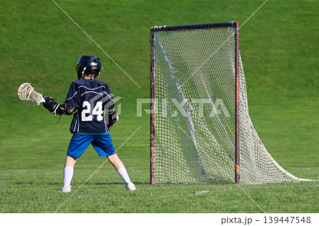 Boy playing Lacrosse game Boy playing Lacrosse game 139447548