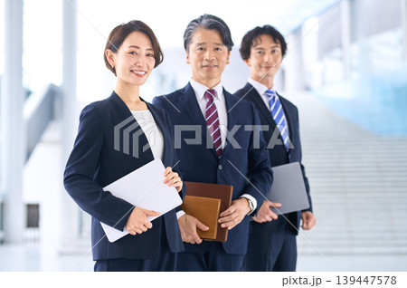 笑顔の女性ビジネスパーソンが前に立つチームの3人・屋内 笑顔の女性ビジネスパーソンが前に立つチームの3人・屋内 139447578