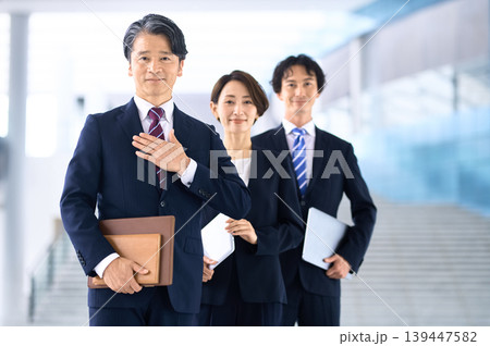 胸に手を当て自己紹介する中年男性ビジネスマンとチーム 胸に手を当て自己紹介する中年男性ビジネスマンとチーム 139447582