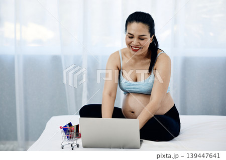 Happy pregnant woman using laptop for online shopping at home, modern motherhood and ecommerce lifestyle concept with digital payment, prenatal preparation and family spending Happy pregnant woman using laptop for online shopping at home, modern motherhood and ecommerce lifestyle concept with digital payment, prenatal preparation and family spending 139447641