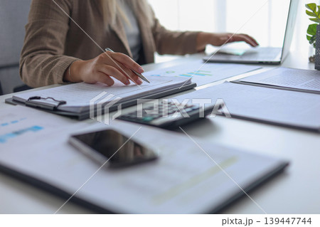 Closeup Female Executive Working on Budget Planning with Calculator and Charts. 139447744