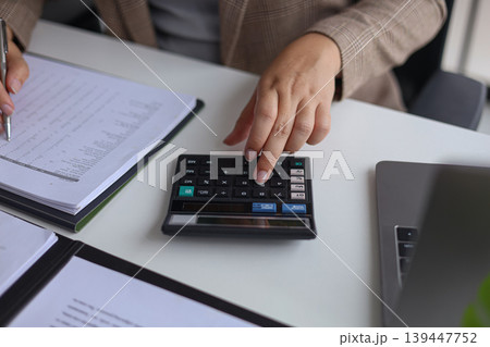 Professional Businesswoman Calculating and Analyzing Financial Documents in the Office. Professional Businesswoman Calculating and Analyzing Financial Documents in the Office. 139447752