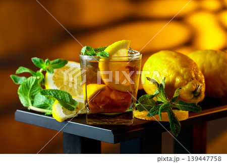 Iced black tea with lemon wedges, ice cubes and mint leaves. Iced black tea with lemon wedges, ice cubes and mint leaves. 139447758