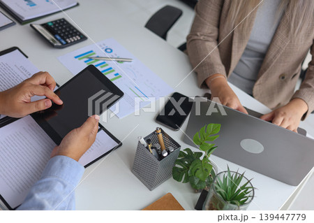 Business Partners Discussing Investment Portfolio with Laptop and Digital Tablet. 139447779