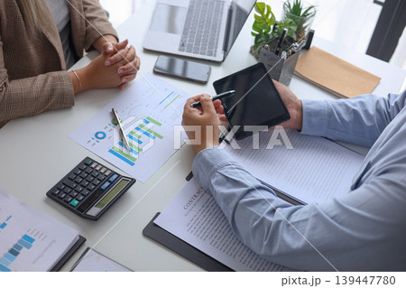 Professional Team Collaborating on Financial Data and Business Strategy in Modern Office. Professional Team Collaborating on Financial Data and Business Strategy in Modern Office. 139447780