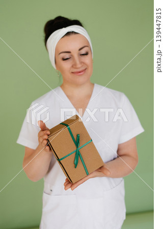Woman In White Uniform Holding Brown Gift 139447815