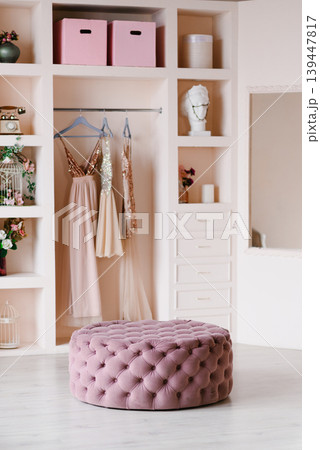 Elegant Pastel Wardrobe Interior With Pink Velvet Ottoman And Evening Dresses Elegant Pastel Wardrobe Interior With Pink Velvet Ottoman And Evening Dresses 139447817