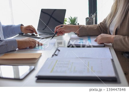 Two Business Partners Discussing Analyzing Financial Data and Business Strategy for Budget Planning in Modern Office. 139447846