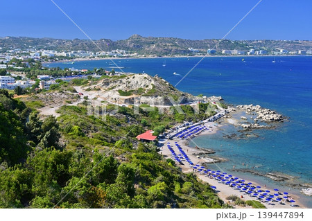 Golden sandy beach on Rhodes, Greece, with gentle waves and blue horizon, ideal holiday destination. Golden sandy beach on Rhodes, Greece, with gentle waves and blue horizon, ideal holiday destination. 139447894