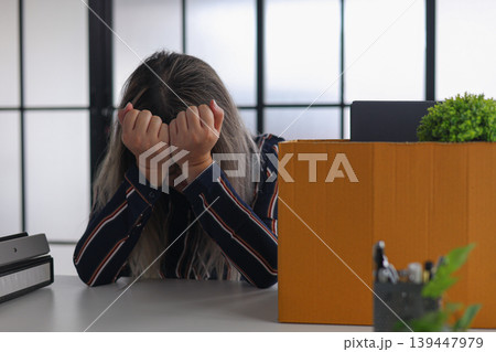 Sad Businesswoman Packing Personal Items After Being Fired. Sad Businesswoman Packing Personal Items After Being Fired. 139447979