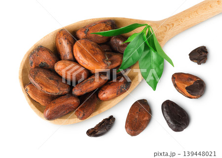 cocoa beans in wooden spoon isolated on white background. Top view. Flat lay cocoa beans in wooden spoon isolated on white background. Top view. Flat lay 139448021