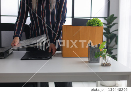 Close-up of Employee Packing Stuff from Working Desk After Quitting Job. Close-up of Employee Packing Stuff from Working Desk After Quitting Job. 139448293
