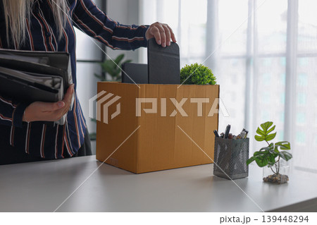 Employee Packing Personal Items in Box After Being Fired or Resigning from Corporate job. Employee Packing Personal Items in Box After Being Fired or Resigning from Corporate job. 139448294