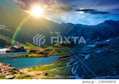 beautiful alpine scenery of mountains. day meet night. sun and moon over lake in romania mountain landscape. summer solstice weather with epic sky. rippled water near rocky slope. travel background beautiful alpine scenery of mountains. day meet night. sun and moon over lake in romania mountain landscape. summer solstice weather with epic sky. rippled water near rocky slope. travel background 139448850