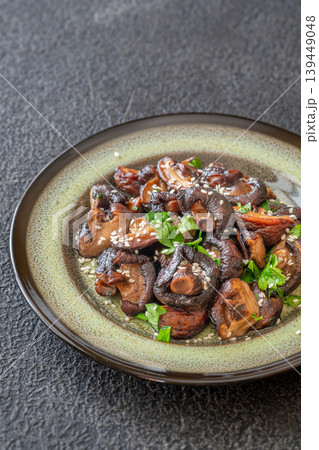 Pan fried shiitake mushrooms with sesame seeds on artisanal ceramic plate 139449048