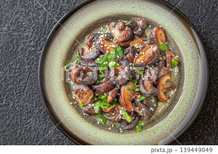 Pan fried shiitake mushrooms with sesame seeds on artisanal ceramic plate 139449049