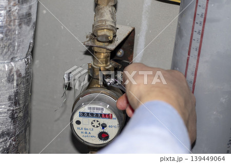 Plumber repairing a residential water meter Plumber repairing a residential water meter 139449064